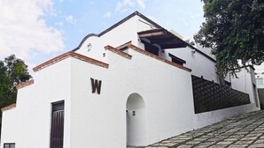 A white building with a 'W' sign, a tiled entrance, and a stone staircase. - Room-cozy Room With Terrace 5 (Mexico City)