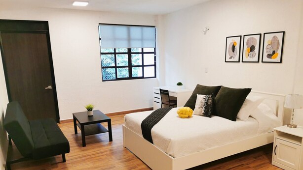 A bedroom with a bed, a chair, a small table, a desk, and a window. - Room-cozy Room With Terrace 5 (Mexico City)