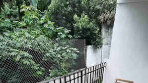 A balcony with a wooden floor, a metal fence, and a bench. - Room-cozy Room With Terrace 5 (Mexico City)