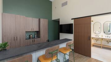 A modern kitchen with wooden cabinets, a black countertop, and two bar stools.