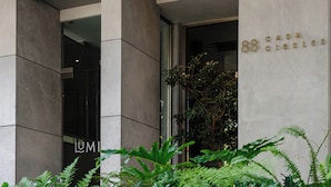 A modern building entrance with a sign reading "Casa Cubeles" and a visible "LUMI" sign on the door. - Casa Cibeles by Lumina (Mexico City)