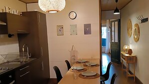 A modern kitchen with dark cabinets, a wooden dining table set for four, and a decorative bowl on the table.