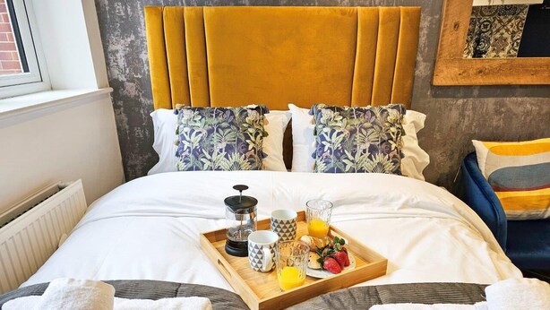 Een hotelkamer met een bed, een dienblad met ontbijtartikelen en een raam met uitzicht.
