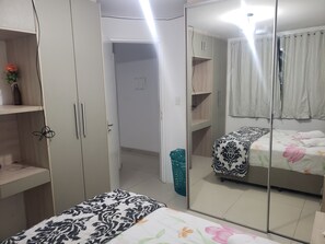 A bedroom with a bed, a wardrobe, and a mirror. - Apartamento Casal Confort João Pessoa-pb (João Pessoa)