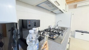 Eine moderne Küche mit Gasherd, Backofen, Kühlschrank und Spüle.