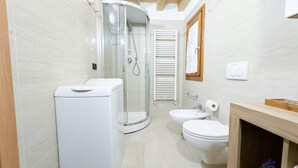 Ein modernes Badezimmer mit Duschkabine aus Glas, Toilette und Waschbecken.