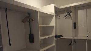 Ein begehbarer Kleiderschrank mit mehreren Regalen und Platz zum Aufhängen von Kleidung.