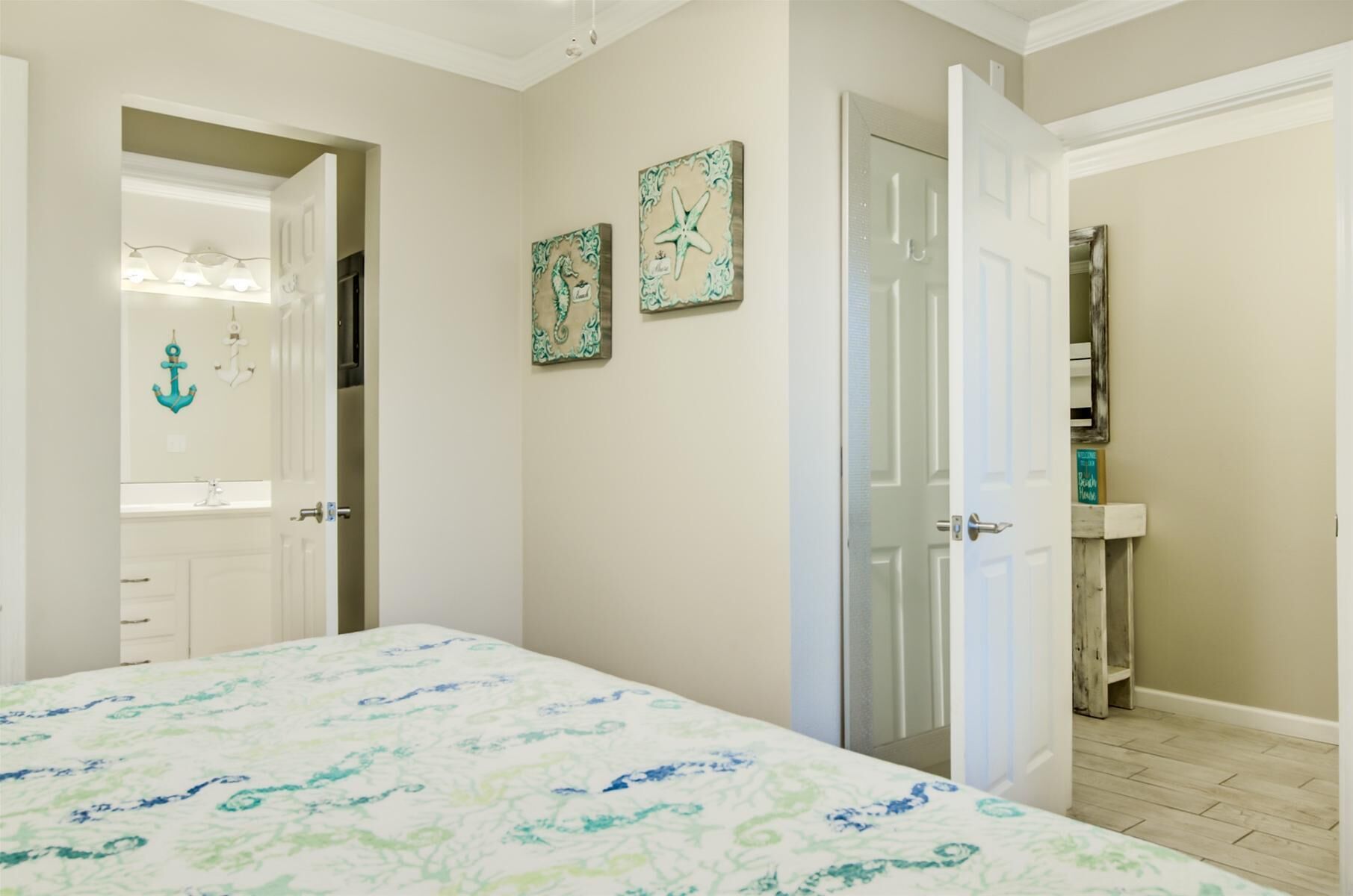 A bedroom with a bed, a door, and a bathroom visible through an open door.