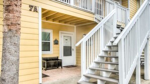 A two-story house with a covered porch, a staircase, and a door with a window. - 7A, Vacay All Day (Miramar Beach)