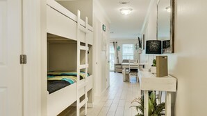 A narrow hallway with bunk beds on one side and a desk area on the other. - 7A, Vacay All Day (Miramar Beach)
