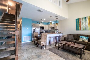 A spacious living area with a staircase, a kitchen with a bar, and a dining area. - 9 G, Two Bedroom Condo (Destin)