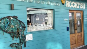 Un bâtiment de couleur turquoise sur lequel on peut lire l’inscription : « Les poissons de demain sont toujours dans la mer » et « ROCKFISH ».