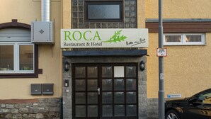 Um edifício com placa indicando ROCA Restaurant & Hotel.