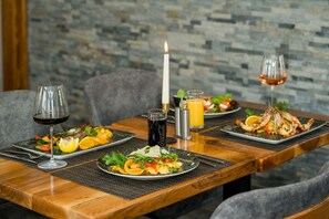A dining table set with plates of food, glasses of wine, and a lit candle. - ROCA Restaurant & Hotel (Oberursel)