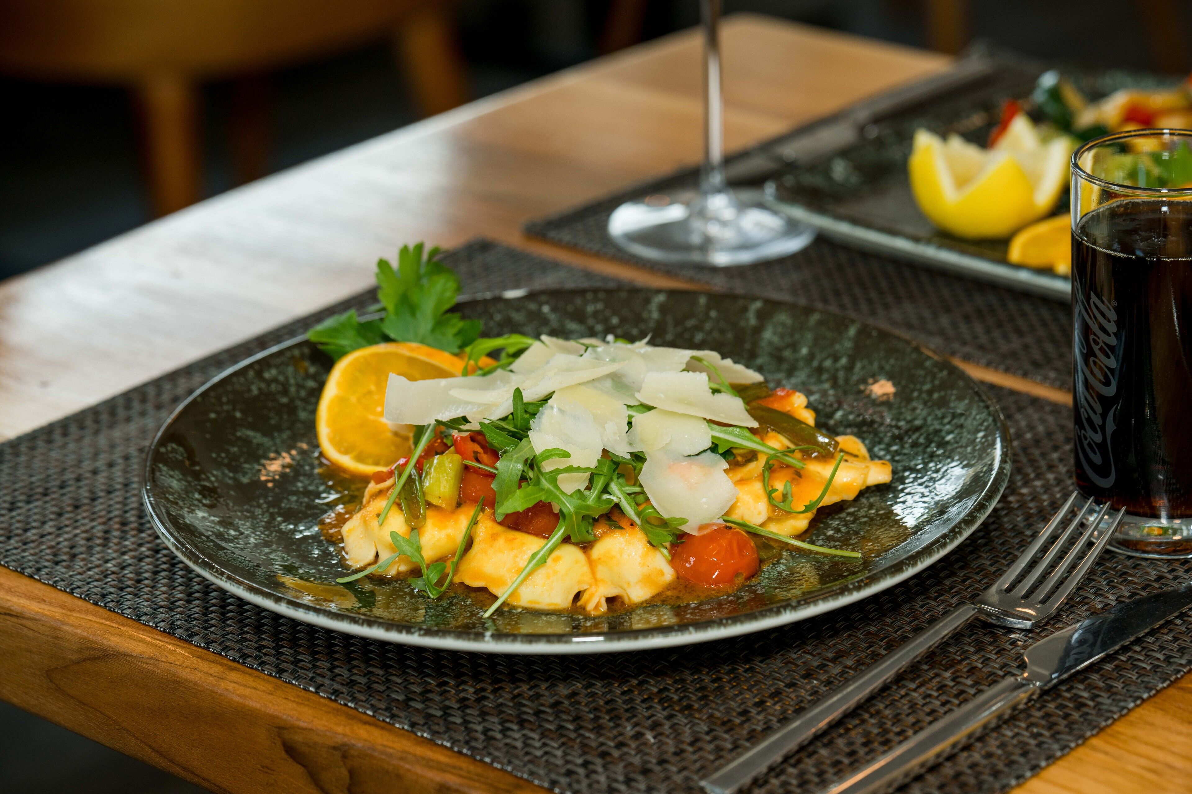 A plate of food with a glass of Coca-Cola on a table.