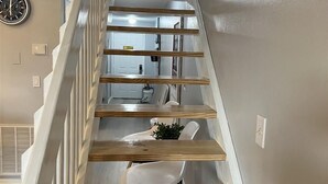 A wooden staircase with white railings leading to a bedroom with a bed and a dolphin decoration. - Isle Be Back (Miramar Beach)