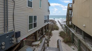A wooden boardwalk leading to a beach with a view of the ocean. - Meet Me at The Gulf (Destin)