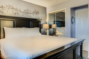 A hotel room with a large bed, two bedside lamps, a decorative wall piece, and a mirror. - 7E, Shell We Stay? (Miramar Beach)