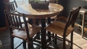 A dining area with a round table and six wooden chairs, a ceiling fan, and a view through large glass doors. - LaCreek Lodge-5 beds (Martin)