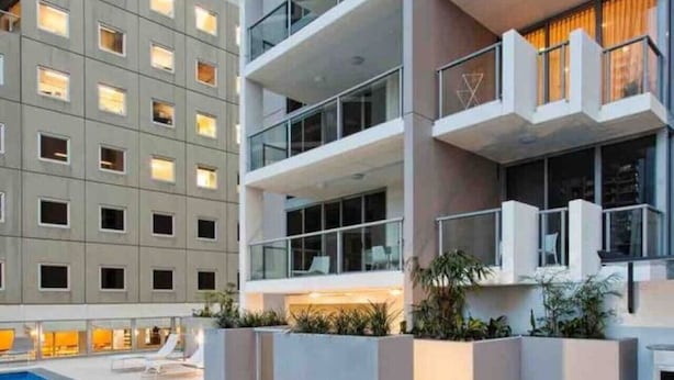 A modern hotel with a swimming pool, multiple balconies, and a well-lit interior. - Urban Redefined - Centre of CBD (Brisbane City)