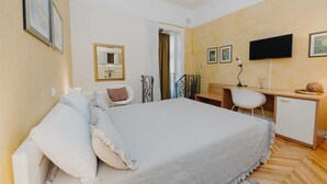 A bedroom with a bed, a desk, a chair, a TV, and a mirror. - VILLA ROSSELLA 2 Studio (La Rosa) (Rovinj)