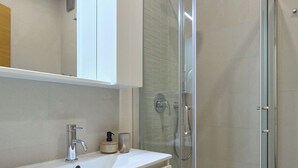 A modern bathroom with a glass-enclosed shower, a white vanity with a sink, and a mirror above the vanity. - Hedera Estate, Hedera Studio 3 (Dubrovnik)