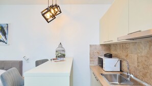A modern kitchen with a central island, a built-in microwave, and a stainless steel sink. - Hedera Estate, Hedera Studio 3 (Dubrovnik)