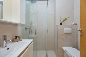 A bathroom with a glass-enclosed shower, a white sink, and a toilet. - Hedera Estate, Hedera Studio 3 (Dubrovnik)