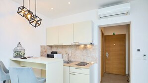 A modern kitchen with white cabinets, a built-in stove, and a pendant light fixture. - Hedera Estate, Hedera Studio 3 (Dubrovnik)