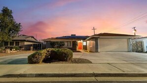 Une maison d’habitation avec un garage, une allée et une pelouse bien entretenue.