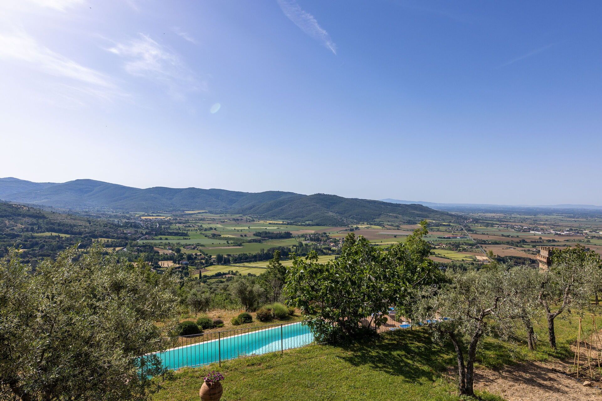 A pool with a clear view of the surrounding landscape, including distant hills and a clear sky.