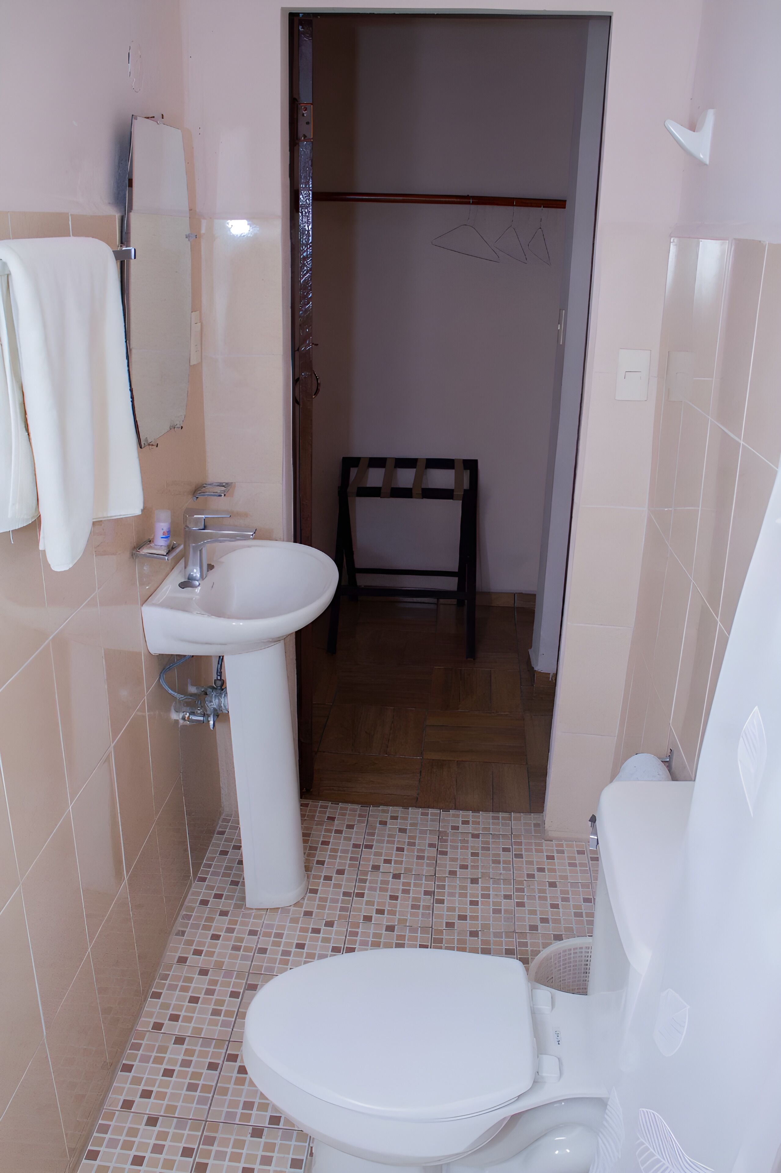 A small bathroom with a white sink, toilet, and a mirror above the sink.