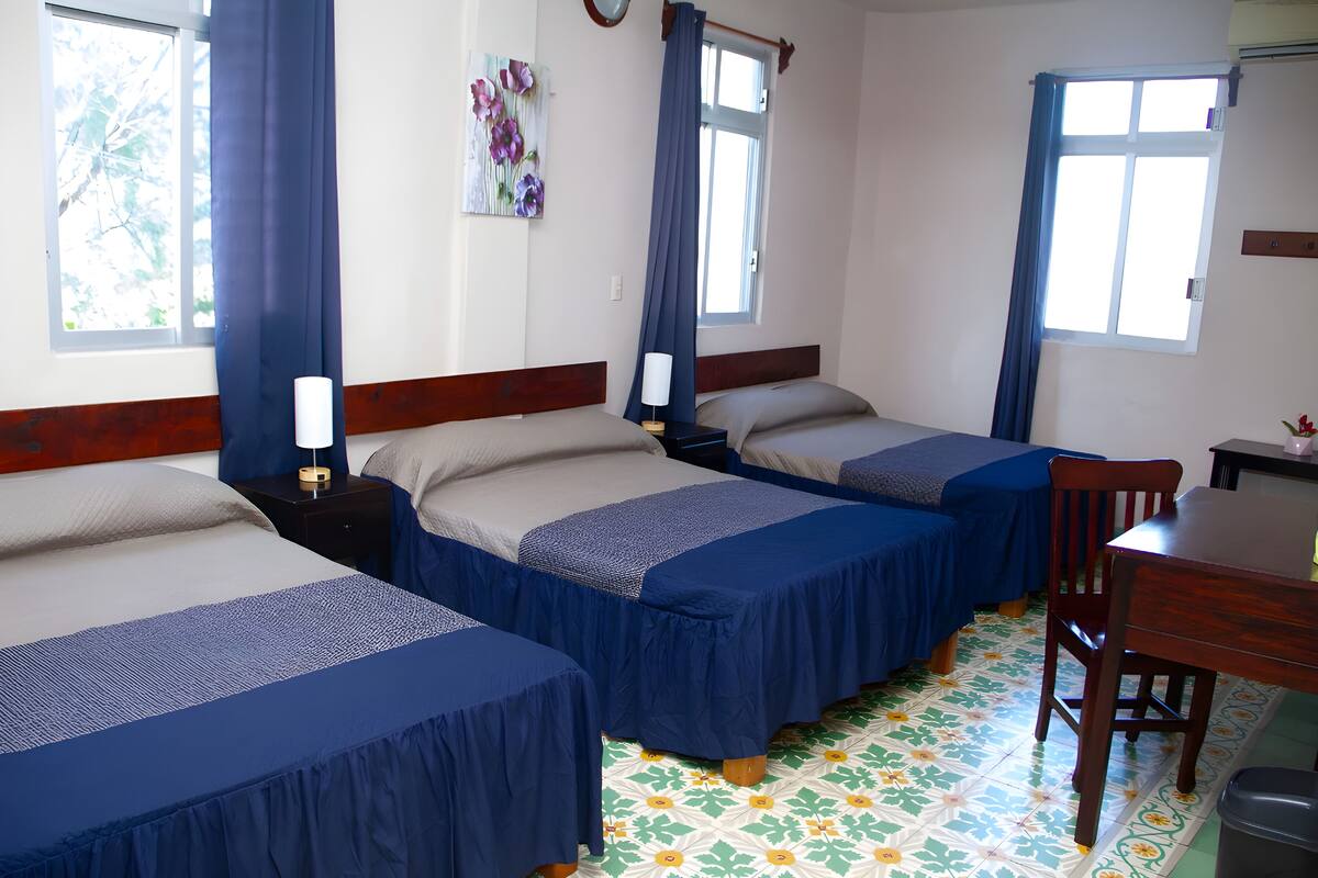 Ein Hotelzimmer mit zwei Betten, einem Schreibtisch und einem Stuhl.