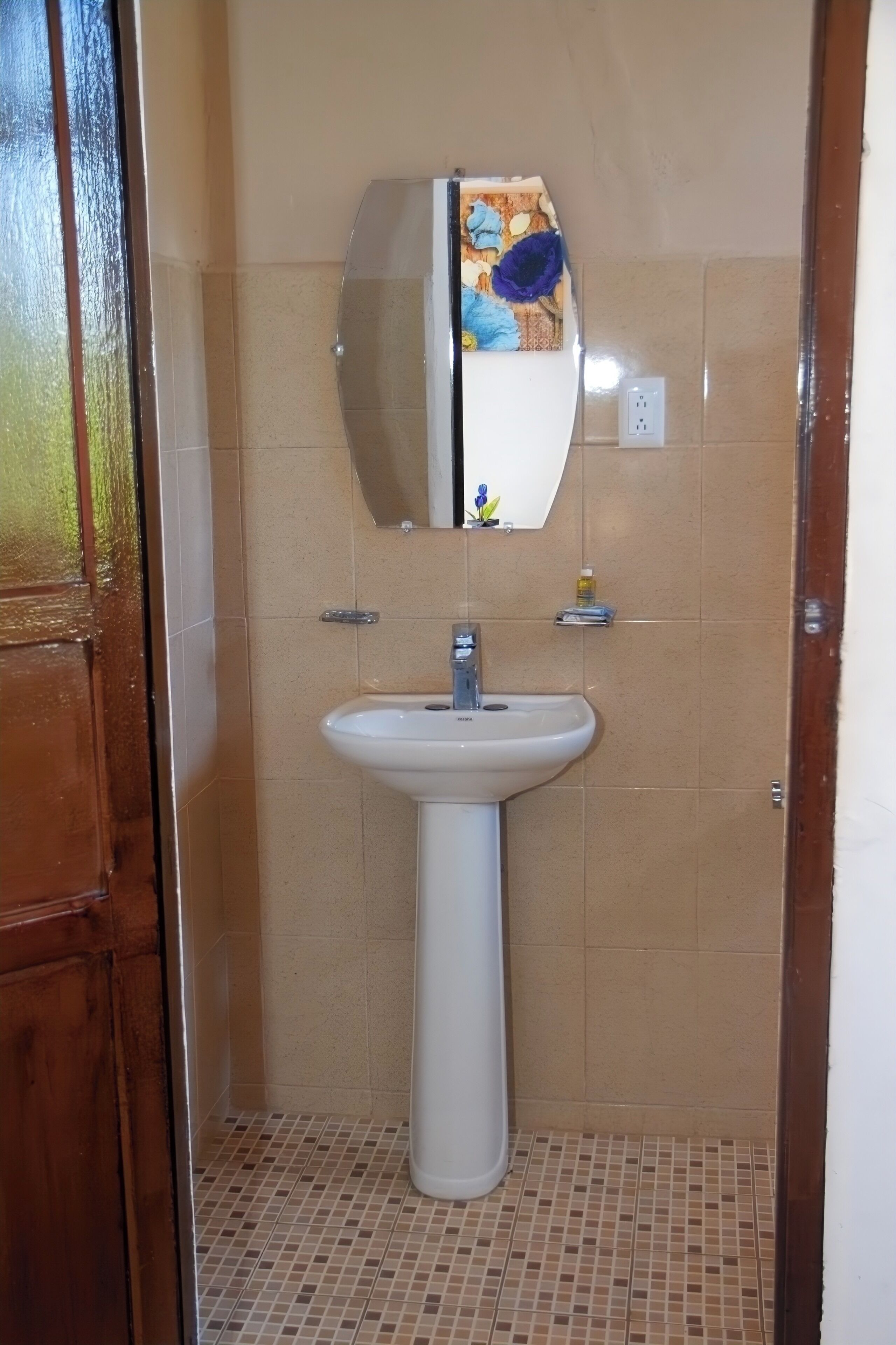 A bathroom with a white sink, a mirror, and a tiled floor.