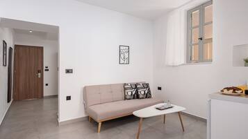 Un salon moderne avec un canapé, une table basse et une fenêtre avec des rideaux.