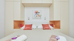 A hotel room with a large bed, two bedside tables, a painting on the wall, and a window. - 3 Double room with balcony and sea view Villa Kate Dadić (Dubrovnik)
