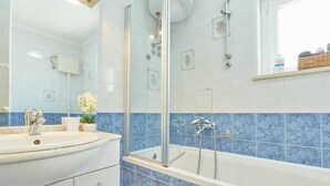 A bathroom with a bathtub, a sink, and a mirror. - 3 Double room with balcony and sea view Villa Kate Dadić (Dubrovnik)