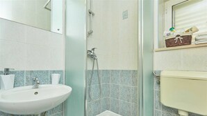 A bathroom with a sink, a shower, and a toilet.
