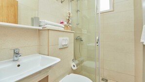 A bathroom with a glass shower enclosure, a white sink, and a toilet. - 6 Double Room in Villa Kate Dadić (Dubrovnik)