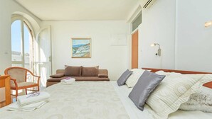 Une chambre d’hôtel avec un lit, un canapé, une chaise et un tableau au mur.