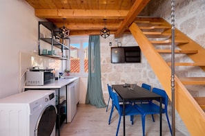 Enjoy meals at the dining table near the kitchen, which features an oven, microwave, and washing machine.