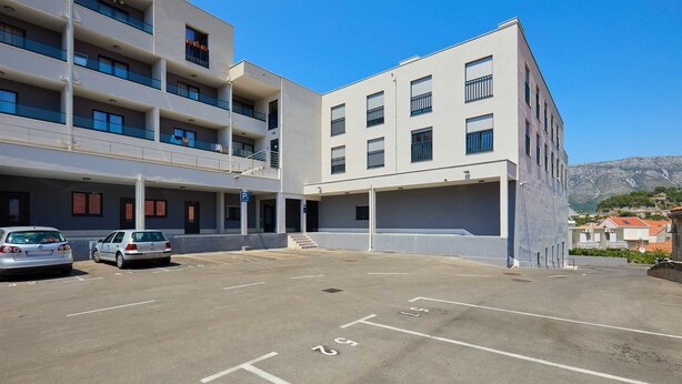 Un parking à étages offrant une vue dégagée sur les bâtiments environnants et sur un paysage montagneux en arrière-plan.