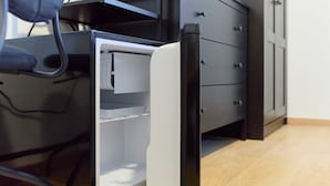 Un bureau moderne doté d'un bloc de tiroirs intégré de couleur blanche, d'une chaise noire et d'un classeur gris.