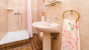 Un baño con bañera, lavamanos y ducha.