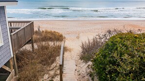 A beach path leading to the ocean with a wooden deck and a building on the left. - Luxe 4 Bedroom Home w/ Ocean views & Quick Private Beach Access in Surf City! (Surf City)