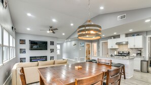 A modern kitchen with white cabinets, a built-in oven, and a stainless steel range hood. - Modern Freeport Home w/ Views: Walk to Beach! (Freeport)