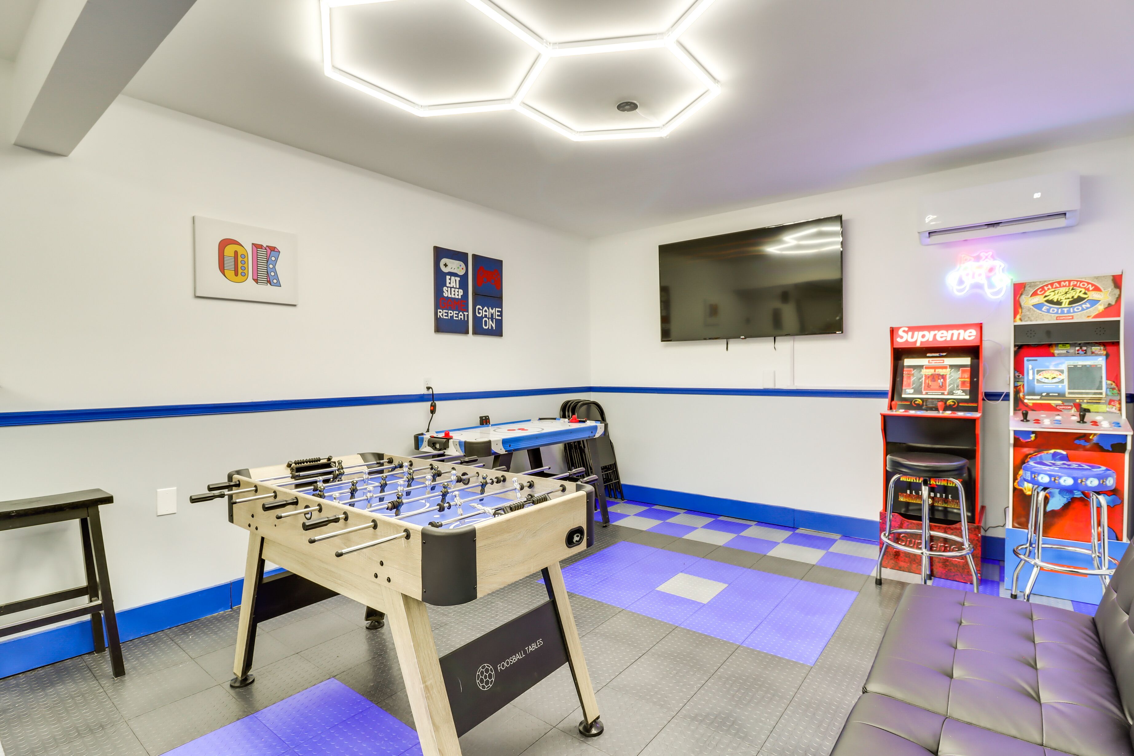 A room with a foosball table, a television, and arcade games.
