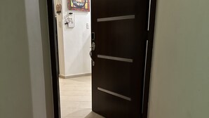 Un pasillo con un felpudo rojo y una puerta marcada con el número 115.