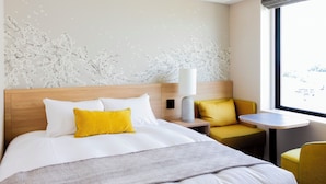 A hotel room with a bed, a nightstand, a lamp, a small table, and a chair. - Hotel Terrace The Garden Mito (Mito)