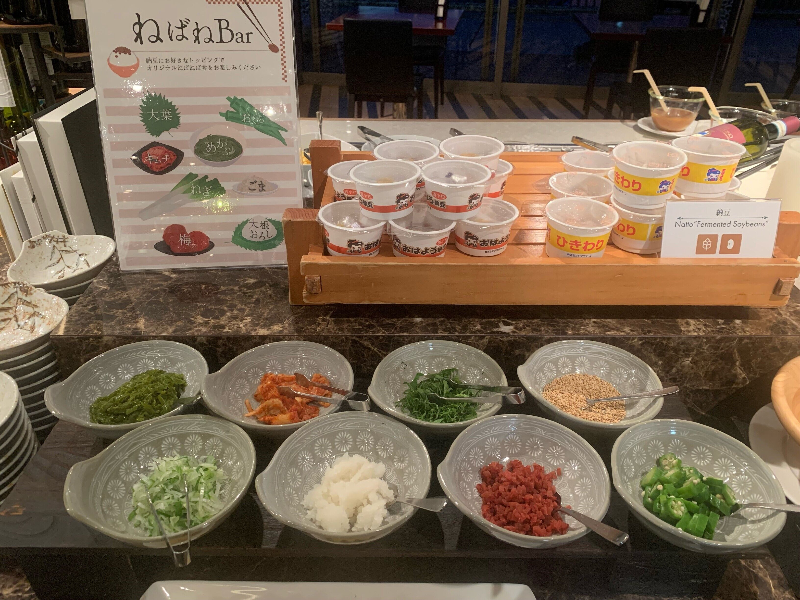 Disposição de buffet com diversos alimentos e recipientes para bebidas.